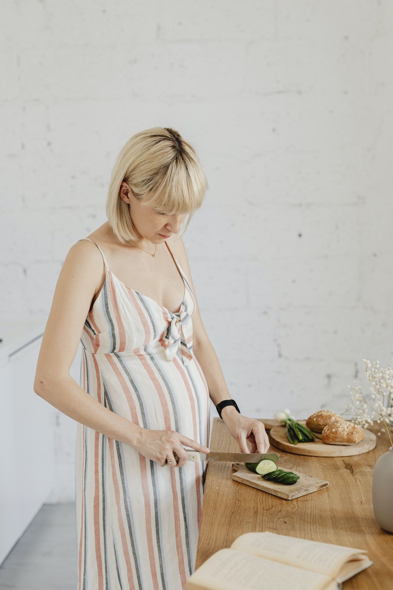 Pregnant woman cooking from a cookbook